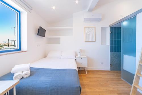 a bedroom with a bed and a desk and a window at Hygge Smart Stays in Lisbon