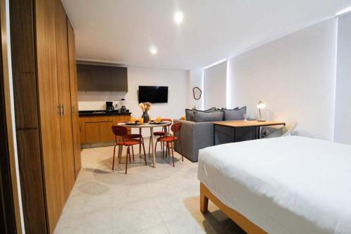 a hotel room with a bed and a table and a kitchen at Tribu Santa Tere in Guadalajara