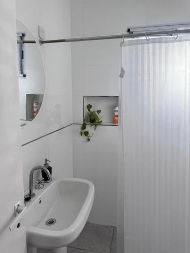 a white bathroom with a sink and a shower at Mística colonial in Gualeguay