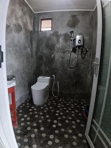 a bathroom with a shower and a toilet at Sunset Beach House in Kudat