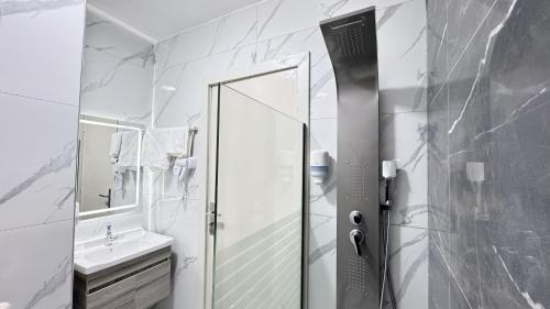 a bathroom with a shower and a sink and a mirror at Ammania Hotel in Amman