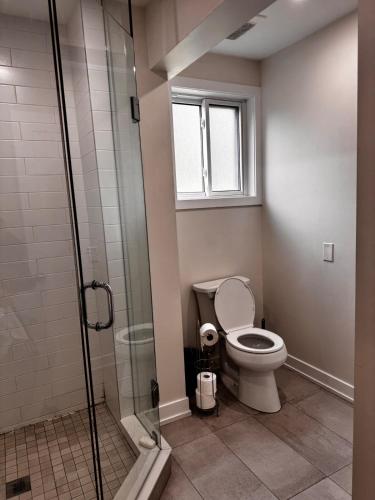 a bathroom with a toilet and a glass shower at Blue Mountain Chalet in Blue Mountains