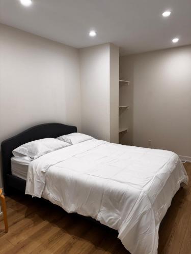 a bedroom with a large bed with white sheets at Blue Mountain Chalet in Blue Mountains