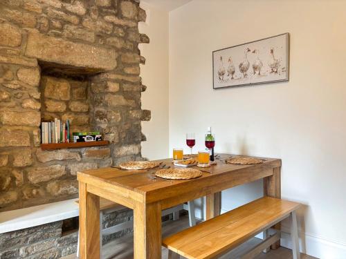 a wooden table with food and glasses of wine at Croft House Cottage in Hebden