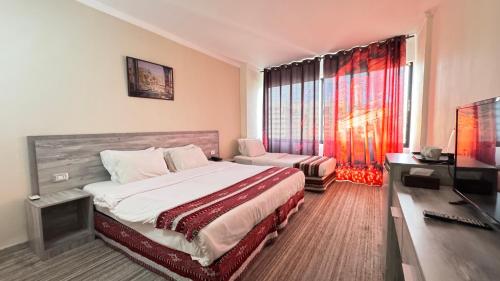 a bedroom with a bed and a desk and a television at Ammania Hotel in Amman