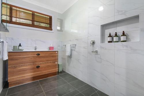 a white bathroom with a sink and a shower at Blue Moon in Beechworth