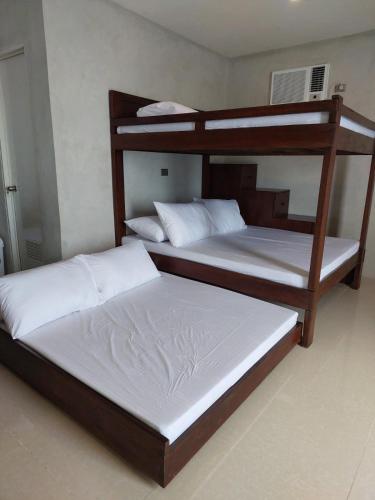 two bunk beds sitting in a room withthritisthritisthritisthritisthritisthritisthritisthritis at Costa Moriah Manticao PH in Manticao