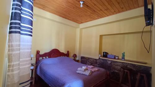 a bedroom with a bed with two towels on it at El MasSi in Tilcara