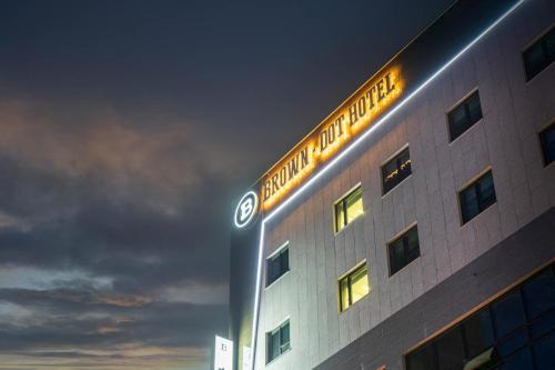 a building with a sign on top of it at night at Browndot Hotel Godeok newtown in Pyeongtaek