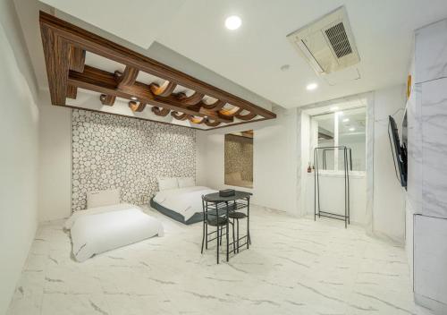 a room with two beds and a table in it at Gunsan Hasen Hotel in Gunsan-si