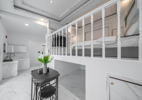 a white bedroom with a bunk bed and a table at Gunsan Hasen Hotel in Gunsan-si