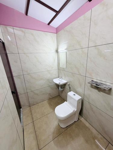 a bathroom with a toilet and a sink at Himadri Retreat Wayanad in Kaniyāmbetta
