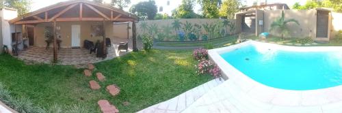 a backyard with a swimming pool and a house at La Rufina Lodge in Puerto Iguazú
