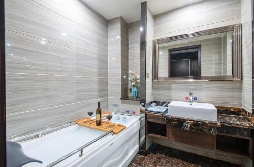 a bathroom with a tub and a sink and a mirror at 帝锦大酒店 in Supoqiao