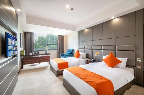 a hotel room with two beds and a television at 帝锦大酒店 in Supoqiao