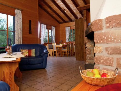 a living room with a couch and a stone fireplace at Feriendorf Reinskopf in der Eifel in Schönecken