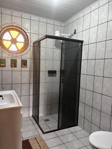 a bathroom with a shower with a toilet and a sink at Espaço vovô Wilson in Joinville