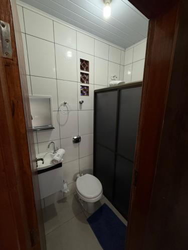a small bathroom with a toilet and a sink at Quarto com area de descanso in Foz do Iguaçu