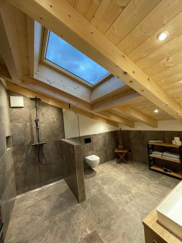 an attic bathroom with a toilet and a window at Haus Hochlenzerblick in Schönau am Königssee
