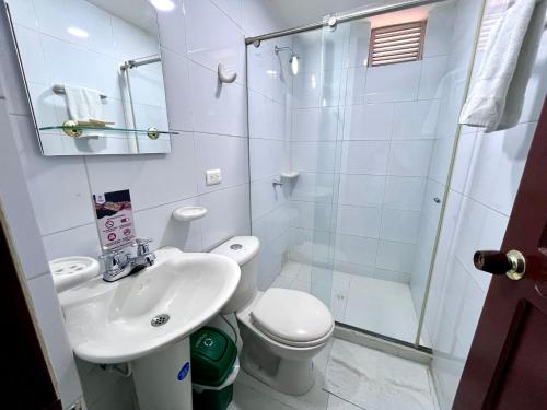 a bathroom with a shower and a toilet and a sink at Hotel Exelsior in Cúcuta