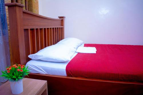 a bed with a red blanket and a pillow on it at Eunia homes in Kibarani