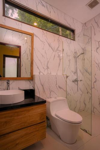 a bathroom with a toilet and a sink and a mirror at Wikubu Villa in Munduk