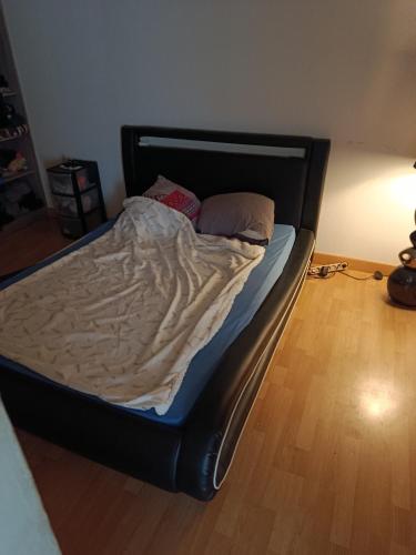 an unmade bed in a bedroom with a wooden floor at Duplex 95m2 Annecy in Annecy