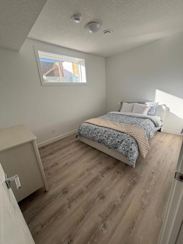 a bedroom with a bed and a wooden floor at Hidden Gem in Airdrie