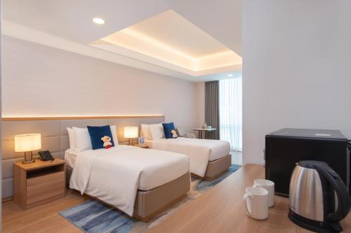 a hotel room with two beds and a television at Somerset Valero Makati in Manila