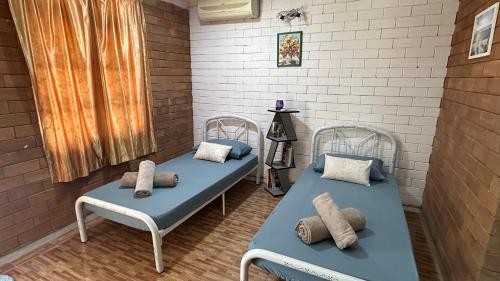 two beds with pillows on them in a room at Homestay Sani in Tanah Merah