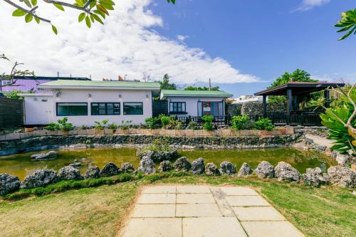 a house with a pond in front of it at 1302海景民宿 in Xiaoliuqiu