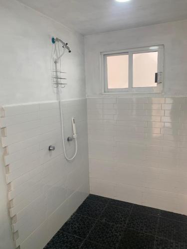 a white bathroom with a shower with a window at Beekind in San Juan Teotihuacán