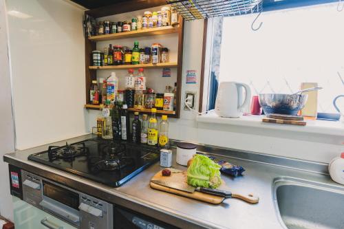 a kitchen counter with a stove and a sink at アーバンジャングル in Tokyo