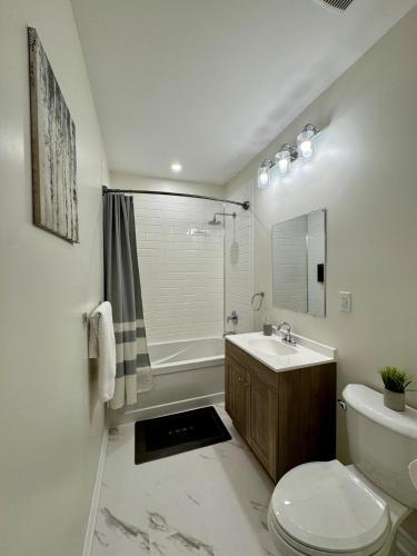 a bathroom with a toilet and a sink and a shower at Spacious High Ceiling Lower Level Suite-New & Cozy in Vaughan