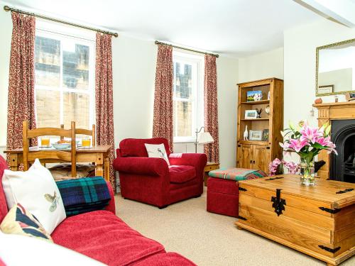 a living room with red furniture and a fireplace at Harry's Den in Alnwick