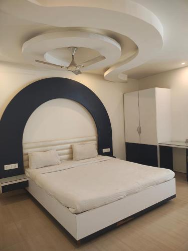 a bedroom with a large bed with a ceiling at Hotel Jyoti Sanjay in Pūrnia