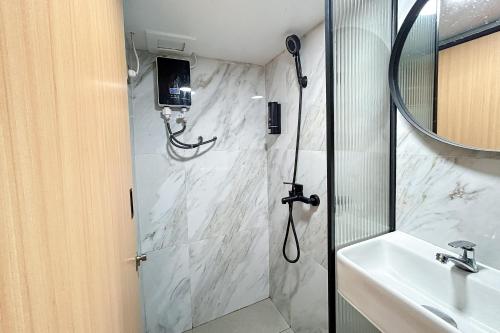 a bathroom with a shower and a sink at Laurel Inn Menteng in Jakarta