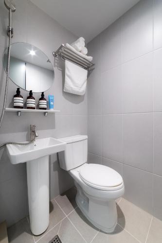 a bathroom with a toilet and a sink and a mirror at 4rest Stay Jongno in Seoul
