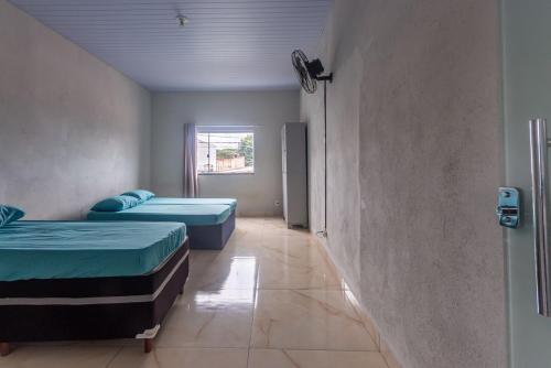 a room with two beds and a hallway at Apartamento para 6 com Vaga e Churrasqueira in Pará de Minas
