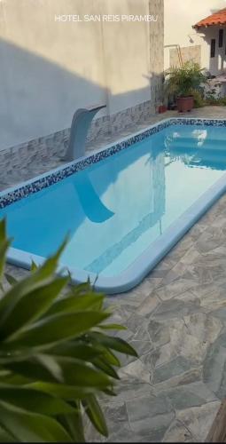 a large swimming pool with a chair in a yard at SR Hotel e Pousada Pirambu in Pirambu