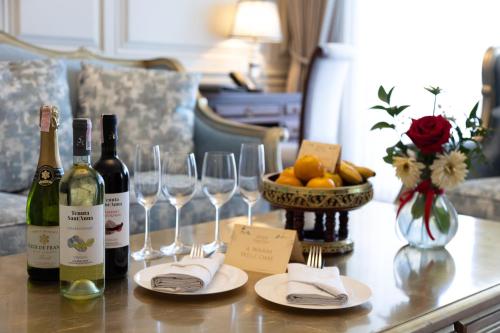 a table with two bottles of wine and wine glasses at Ping Pura Riverside Resort & Spa Chiang Mai in Chiang Mai