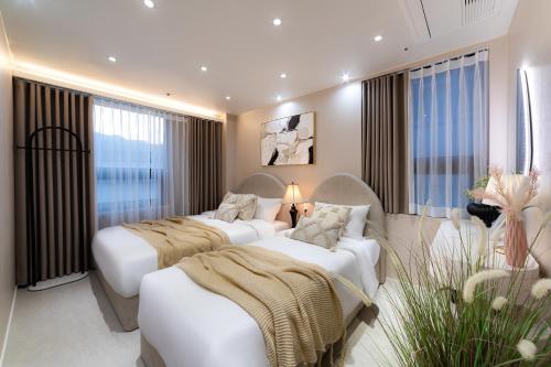 a hotel room with two beds and a couch at 4rest Stay Jongno in Seoul