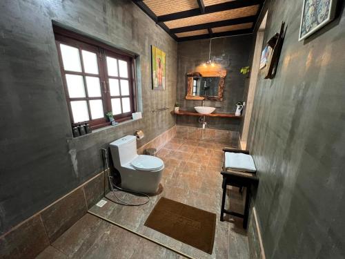 a bathroom with a toilet and a sink at Tree Roots Retreat in Rayong