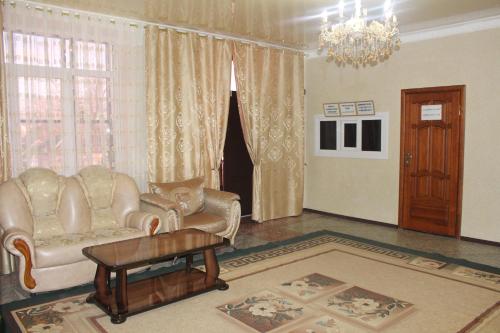 een woonkamer met een bank en een tafel bij Gostinitsa Chetyre Sezona in Groznyy