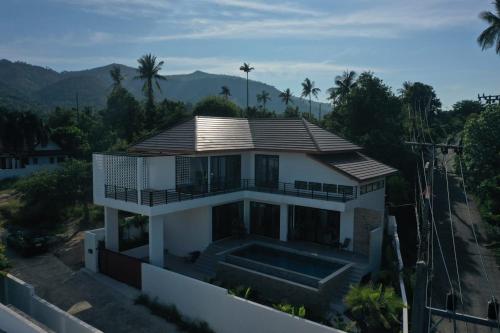 a house with a swimming pool in front of it at Rancho Relaxo Pool Villa in Nathon Bay