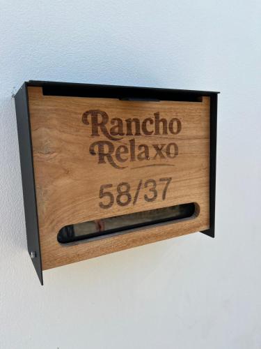 a wooden sign that reads raminoco relaya with a pen at Rancho Relaxo Pool Villa in Nathon Bay
