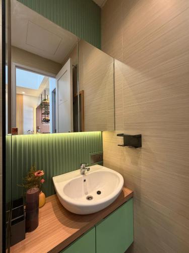 a bathroom with a sink and a mirror at Pendo Mansion in Pulau Sembakau Kecil