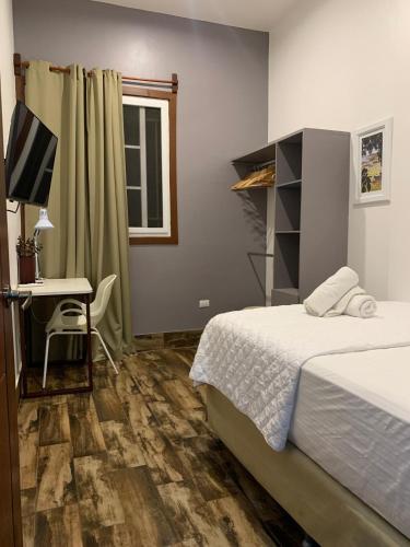a bedroom with a bed and a desk with a computer at Casa G&V X9 personas in Santa Elena