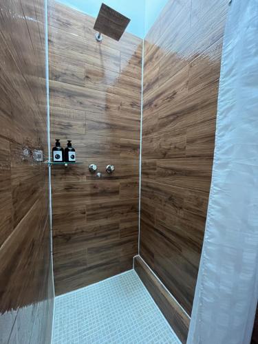 a bathroom with a shower with wooden walls at Casa G&V X9 personas in Santa Elena
