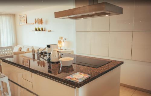 a kitchen with a counter top with a sink at Beach House The Strand in Willemstad